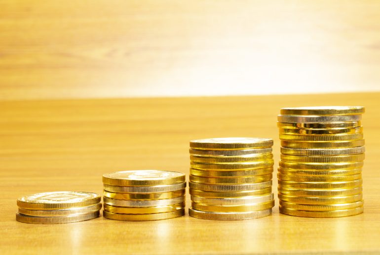 4 rows of coins arranged in ascending order with selective focus and blurred background. Growth concept.